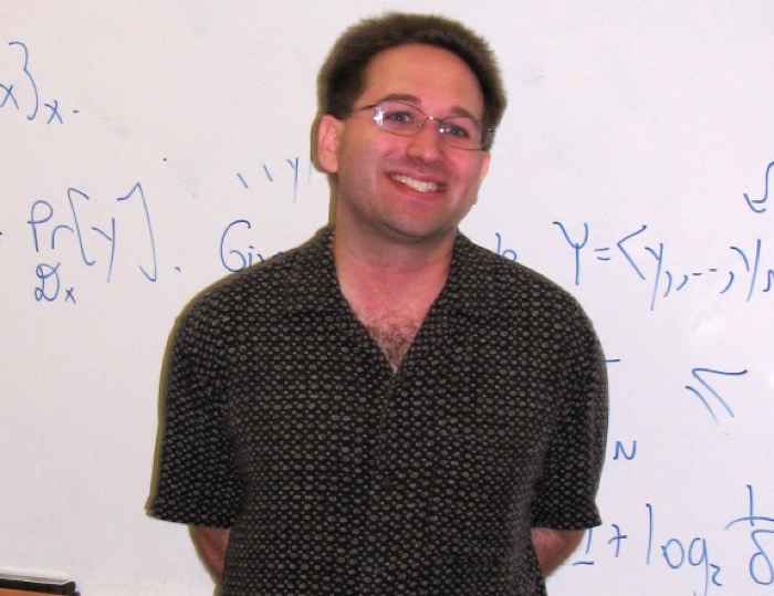 Scott Aaronson standing in front of a whiteboard covered
                      in probability notation.